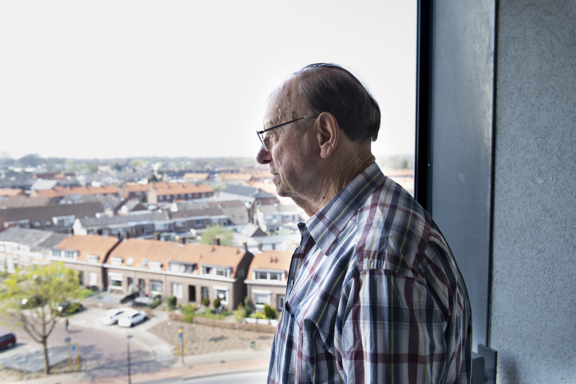 Joop kijkt vanuit het balkon van zijn appartement over de stad Tiel